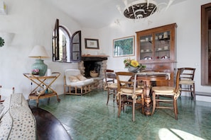 A traditional room with a fireplace, wooden furniture, and a dining table. - Villa 'Dei Tramonti B' with private sea access (Torre Delle Stelle (Maracalagonis))