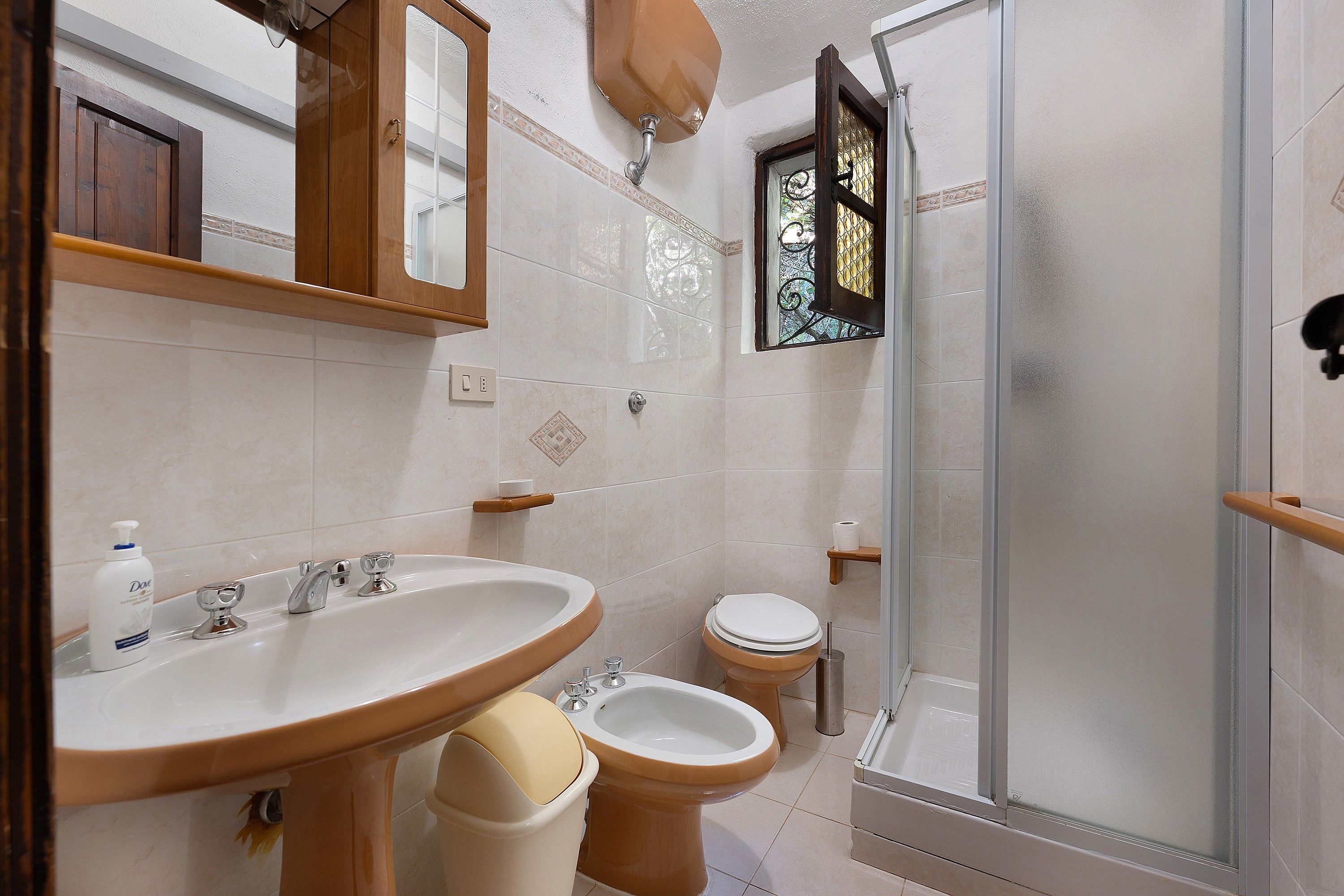 Un bagno con lavandino, bidet, toilette e cabina doccia in vetro.