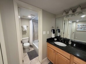 Ein Badezimmer mit Badewanne, Toilette und Waschbecken-Doppelplatz.