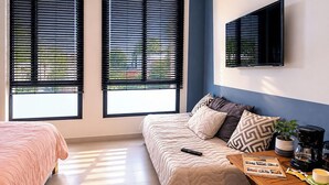 A bedroom with a bed, a sofa, a coffee table, and a TV mounted on the wall. - Acogedor ApartaSuit amoblado/de 1 dormitorio en Montería con aire acondicionado. (Montería)