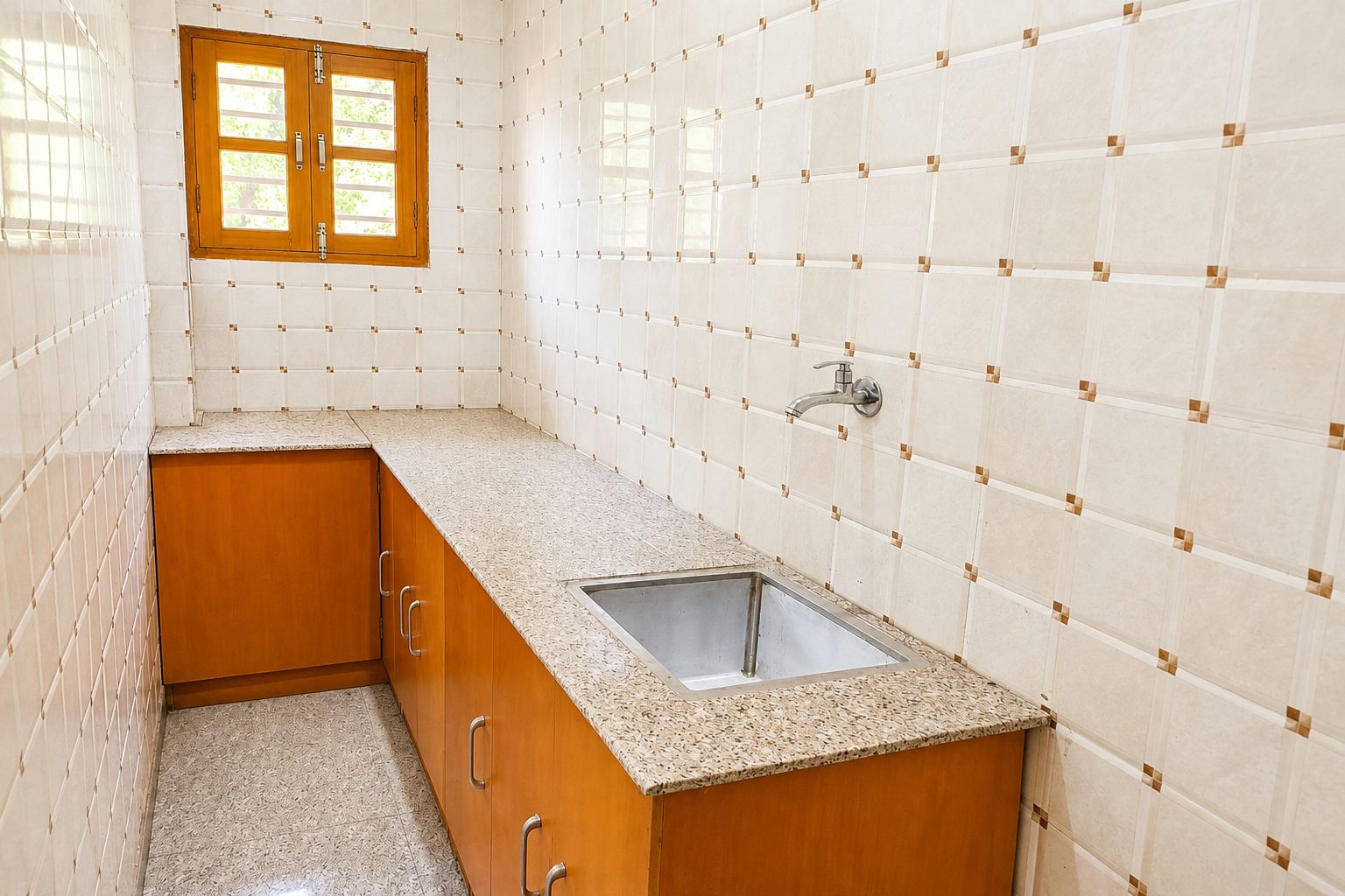 A kitchen with a granite countertop, wooden cabinets, a stainless steel sink, and a window with a view of greenery.