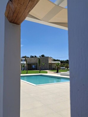 A modern building with a stone facade, a swimming pool, and a clear blue sky. - Fanes Breeze Lodges - Lodge Sykia (Fanes)