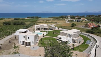 A residential area with modern houses, a swimming pool, and a curved road.