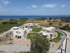 A residential area with modern houses, a swimming pool, and a curved road.