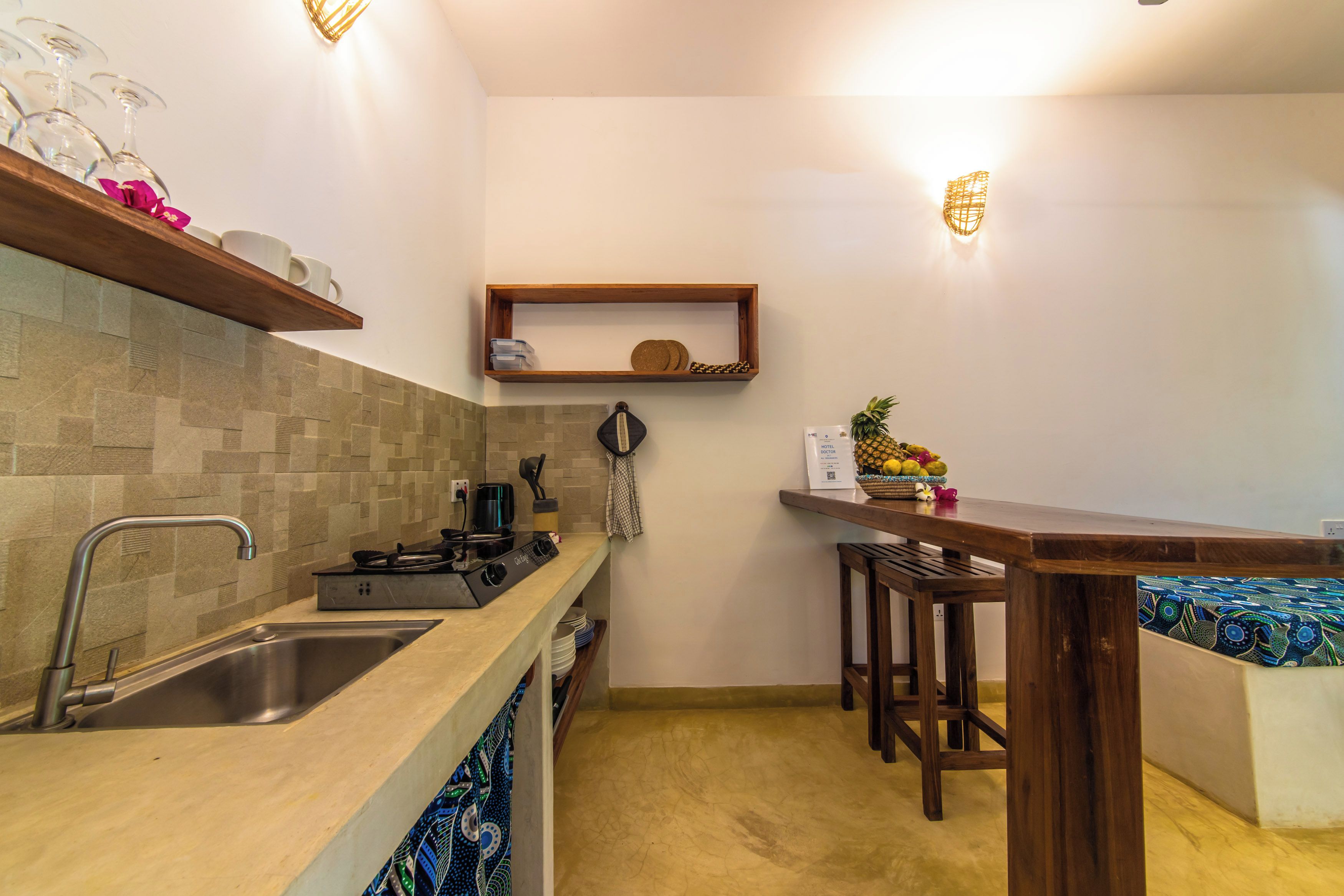A compact kitchen with a sink, stove, and bar area.