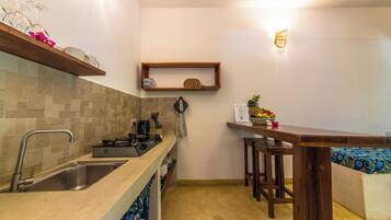 A compact kitchen with a sink, stove, and bar area.