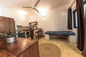 Un espacio habitable compacto con kitchenette, comedor y zona de descanso con cama.