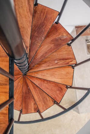 A spiral staircase with wooden steps and metal railings.
