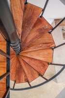 A spiral staircase with wooden steps and metal railings.