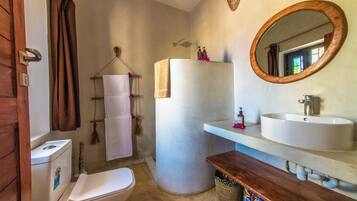 A bathroom with a toilet, a sink, a mirror, and a towel rack.