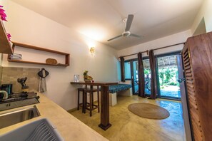 A kitchen with a built-in stove, a wooden table, and a ceiling fan.