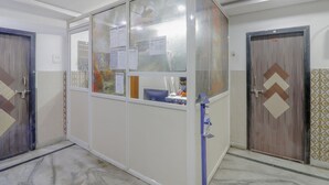 A hotel room with a large cabinet, a desk with a computer, and a door with a decorative pattern. - Deluxe Hotel Ashoka Grand (Sadasivpet)