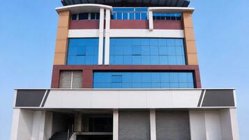 Un edificio de varios pisos con techo plano, ventanas amplias y una entrada cubierta.