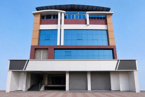 Um edifício de vários andares com telhado plano, janelas amplas e entrada coberta.
