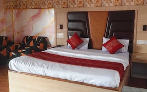 Una habitación de hotel con una cama, una mesita de noche y una pared con estampado floral.