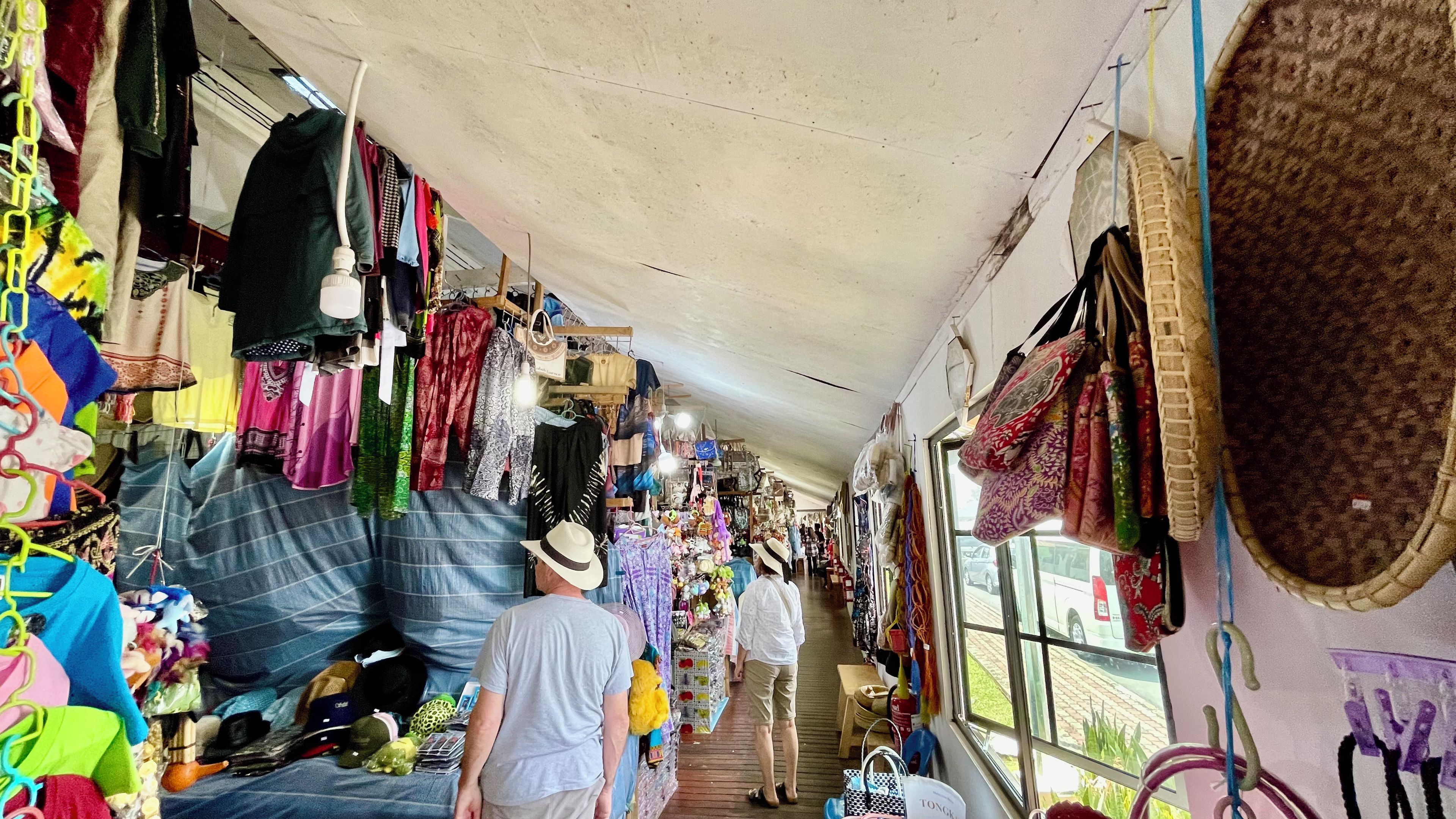 A narrow corridor with various items on display, including bags and clothing.