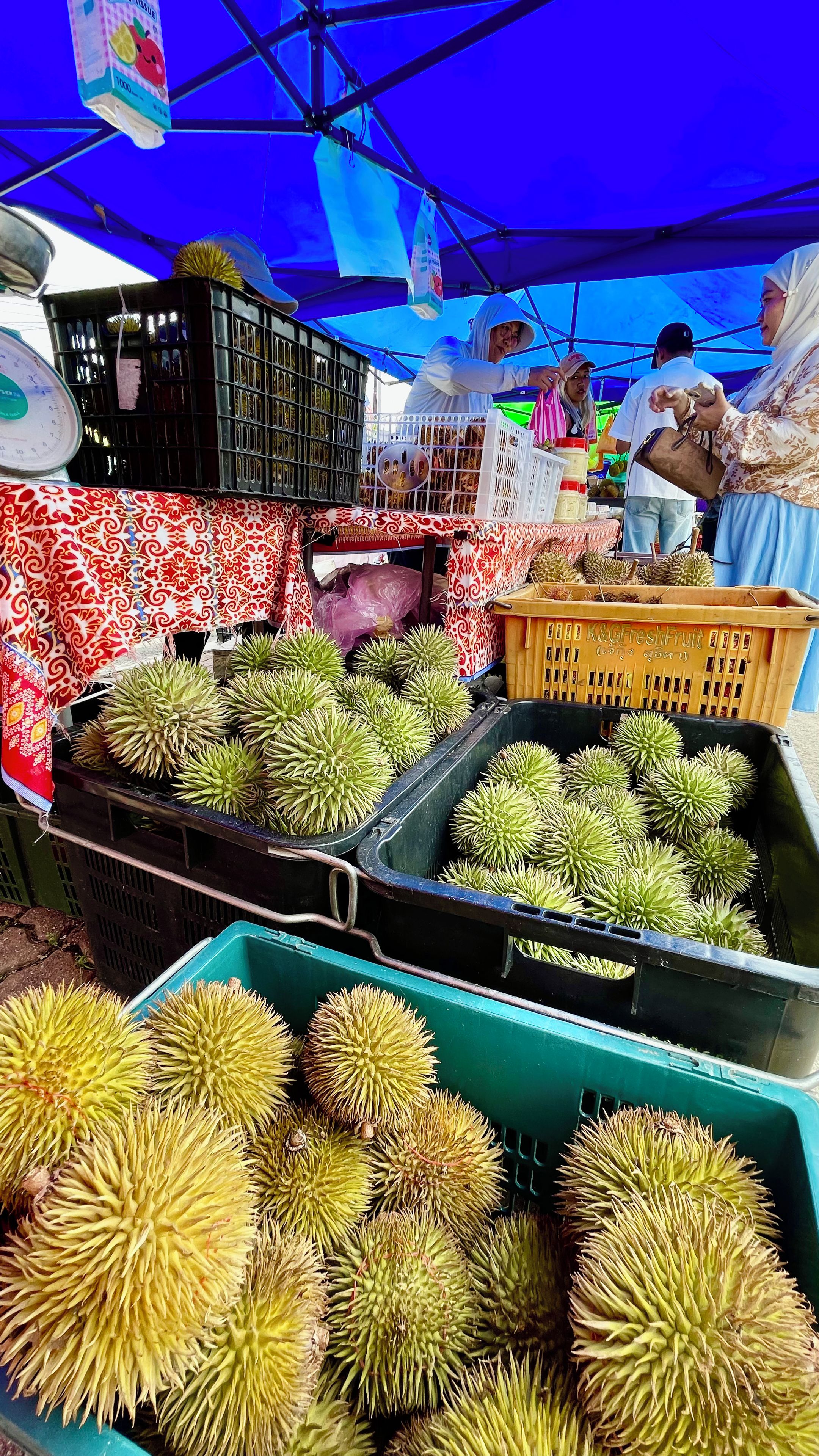 A market stall with durians displayed in crates.