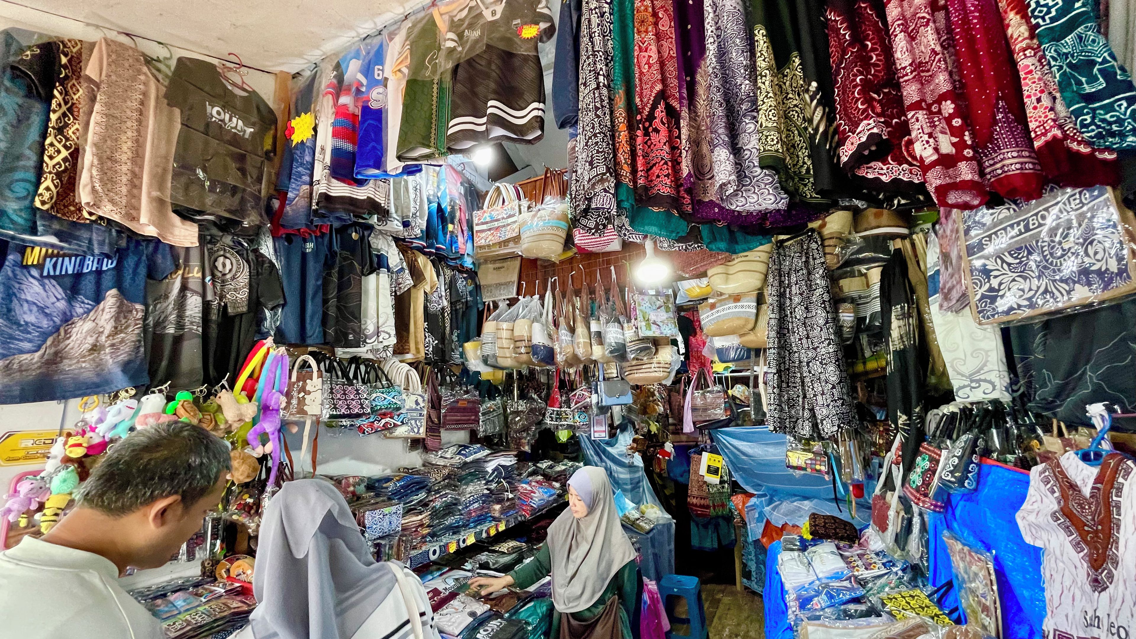 Diverse kledingstukken en accessoires uitgestald in een winkel.