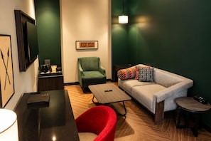 A modern hotel room with a sofa, armchair, and a small table. - Polo Hotel Kohima (Kohima)
