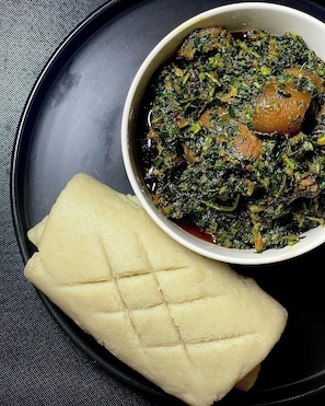 Un plato con un bol de vegetales y una rebanada de pan.