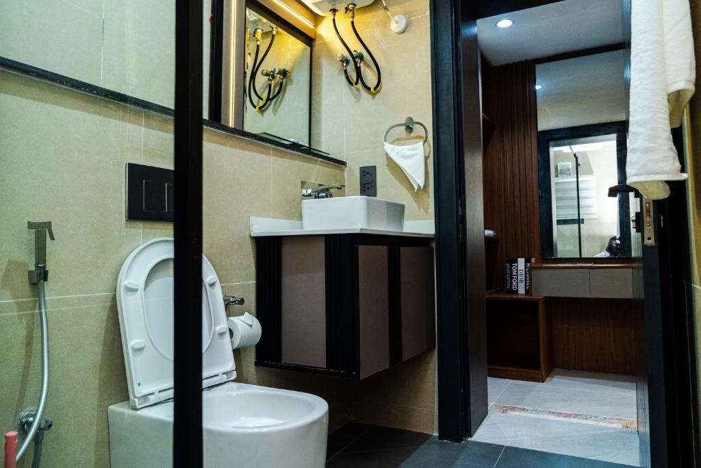Un baño moderno con inodoro, lavamanos y espejo.