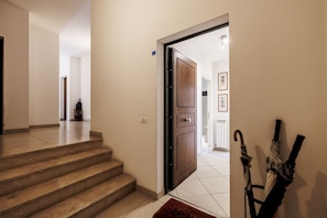 A staircase leading to a room with a wooden door, a tiled floor, and a wall-mounted umbrella. - Bright and cozy 70 sqm apartment, accommodating up to 5 guests, located on the ground floor of an elegant, renovated building dating back to the early 20th century (access involves a few steps). The property is located in a quiet neighborhood offering al (Siena)