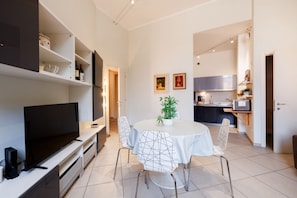 A modern kitchen with white cabinets, a microwave, and a dining area with a round table and chairs. - Bright and cozy 70 sqm apartment, accommodating up to 5 guests, located on the ground floor of an elegant, renovated building dating back to the early 20th century (access involves a few steps). The property is located in a quiet neighborhood offering al (Siena)