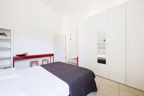 Een moderne hotelkamer met een bed, bureau en stoel.