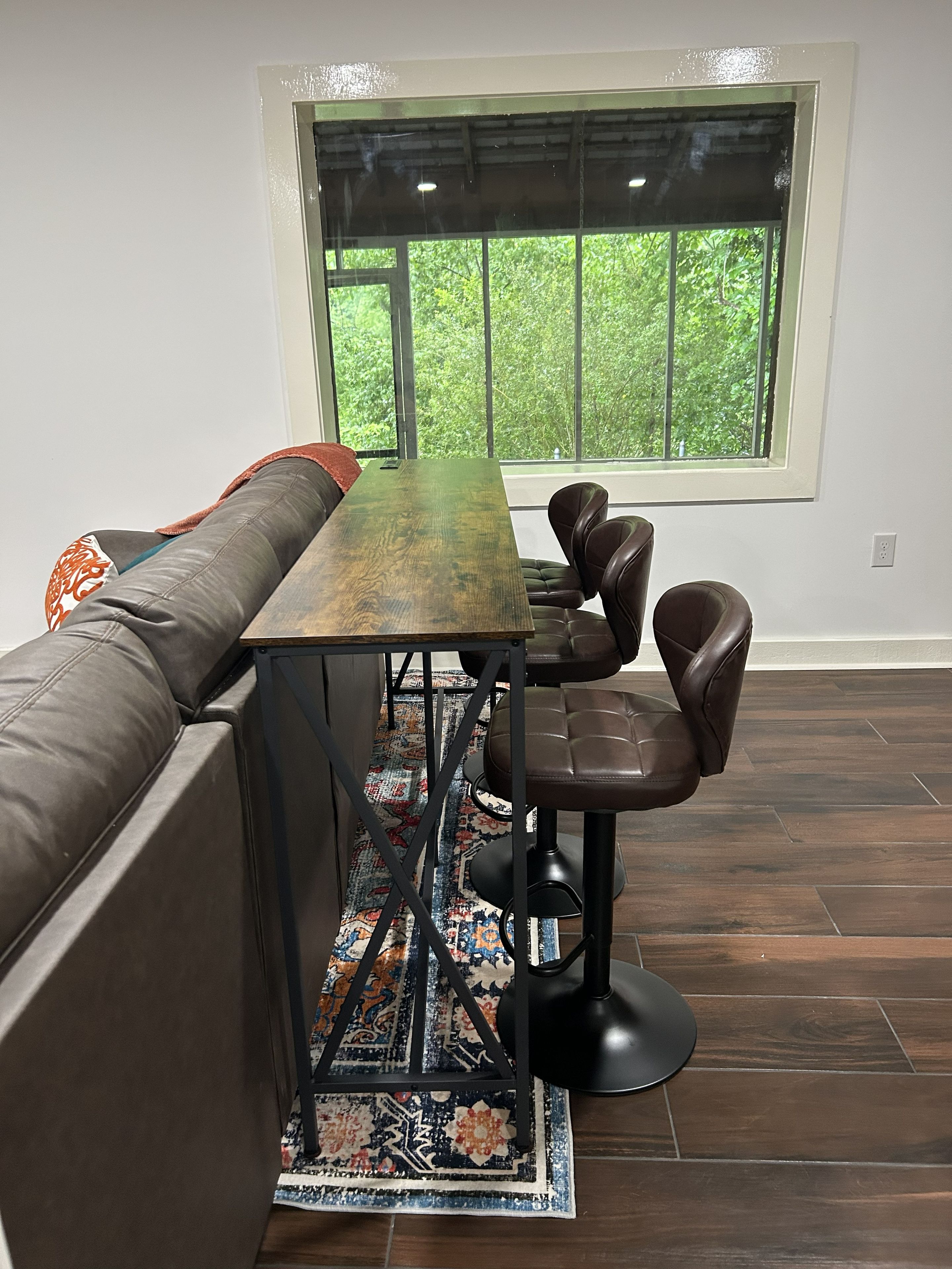 Un espace repas moderne avec une longue table, deux chaises et un banc.