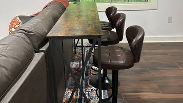 Un espace repas moderne avec une longue table, deux chaises et un banc.