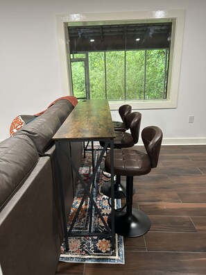 Un espace repas moderne avec une longue table, deux chaises et un banc.