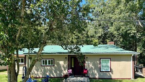 A small building with a green roof, a number '425' sign, and a pathway leading to the entrance.