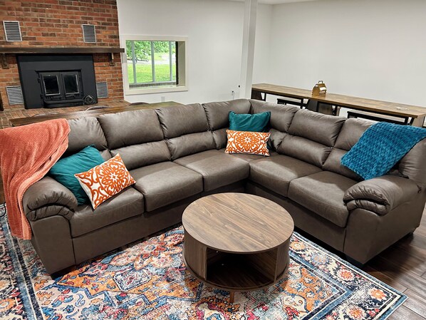 A modern living room with a sectional sofa, a round coffee table, and a patterned rug.