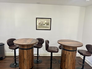 Une pièce comprenant deux tables rondes en bois et six chaises en cuir.