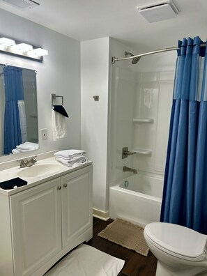 Une salle de bain moderne avec un meuble-lavabo blanc, une douche à parois de verre et des toilettes.