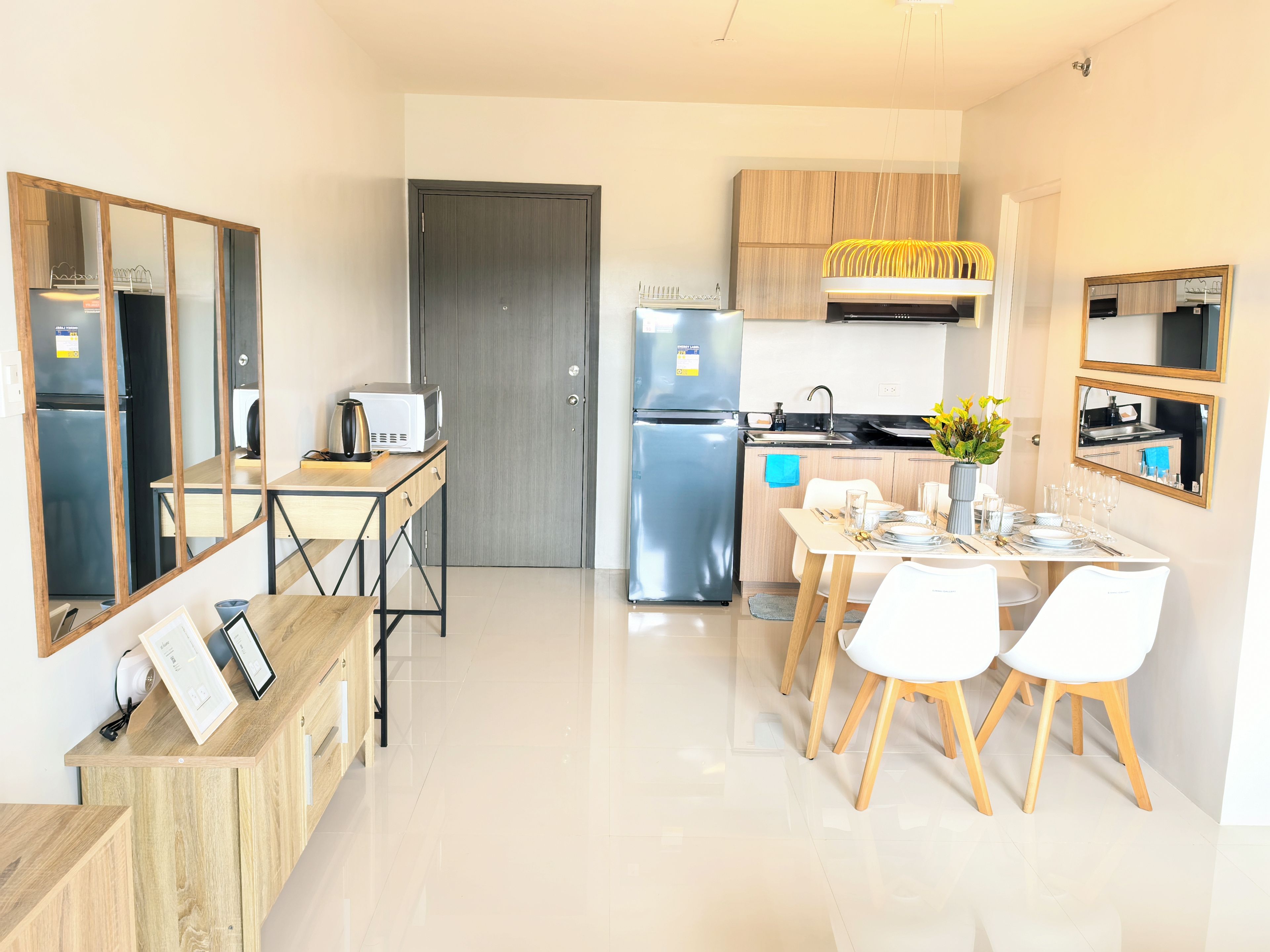 A modern kitchen with a dining area, stainless steel appliances, and wooden cabinetry.