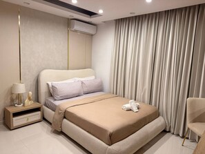 Un dormitorio moderno con una cama, una mesita de noche, una lámpara y una silla.