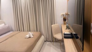 A hotel room with a bed, a desk with a flat-screen TV, a chair, and a vase with flowers. - Nice Apartment Close to Everything (Santo Domingo Norte)
