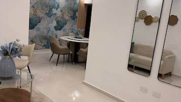 Un comedor moderno con una mesa redonda, sillas y un jarrón decorativo.
