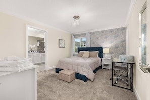A bedroom with a bed, a nightstand, a desk, and a chair. - ChampionsGate 4BR | Private Pool + Waterpark (Kissimmee)