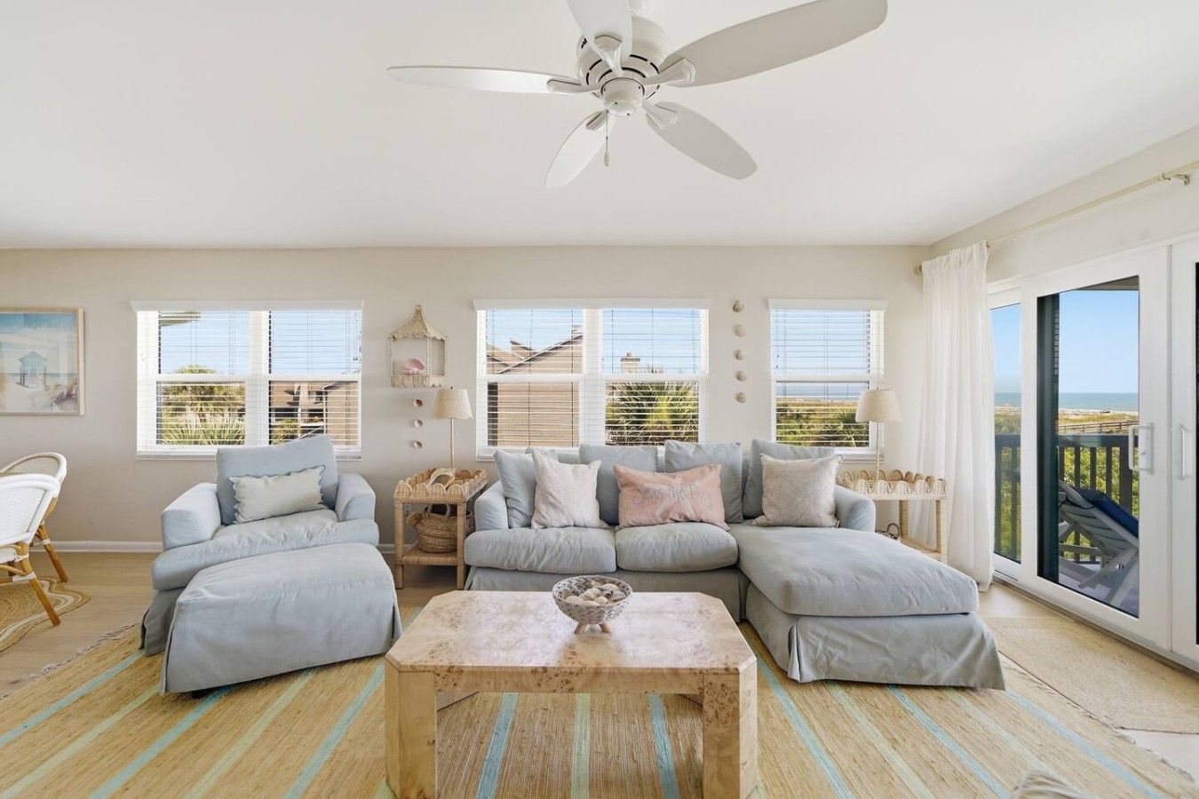 A spacious living room with a large sectional sofa, a wooden coffee table, and a ceiling fan.