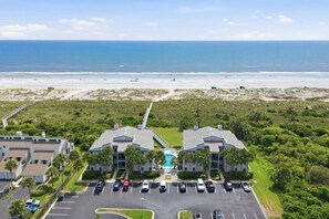 A beachfront property with a swimming pool, parking, and a view of the ocean. - The Shell House • Ocean Front • Beach Access •Pool (St. Augustine)