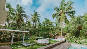 A poolside area with a circular hot tub, palm trees, and a clear sky. - Villa Shankari - Beachside 3BR w Private Pool (Udupi)