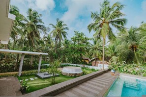 A poolside area with a circular hot tub, palm trees, and a clear sky. - Villa Shankari - Beachside 3BR w Private Pool (Udupi)