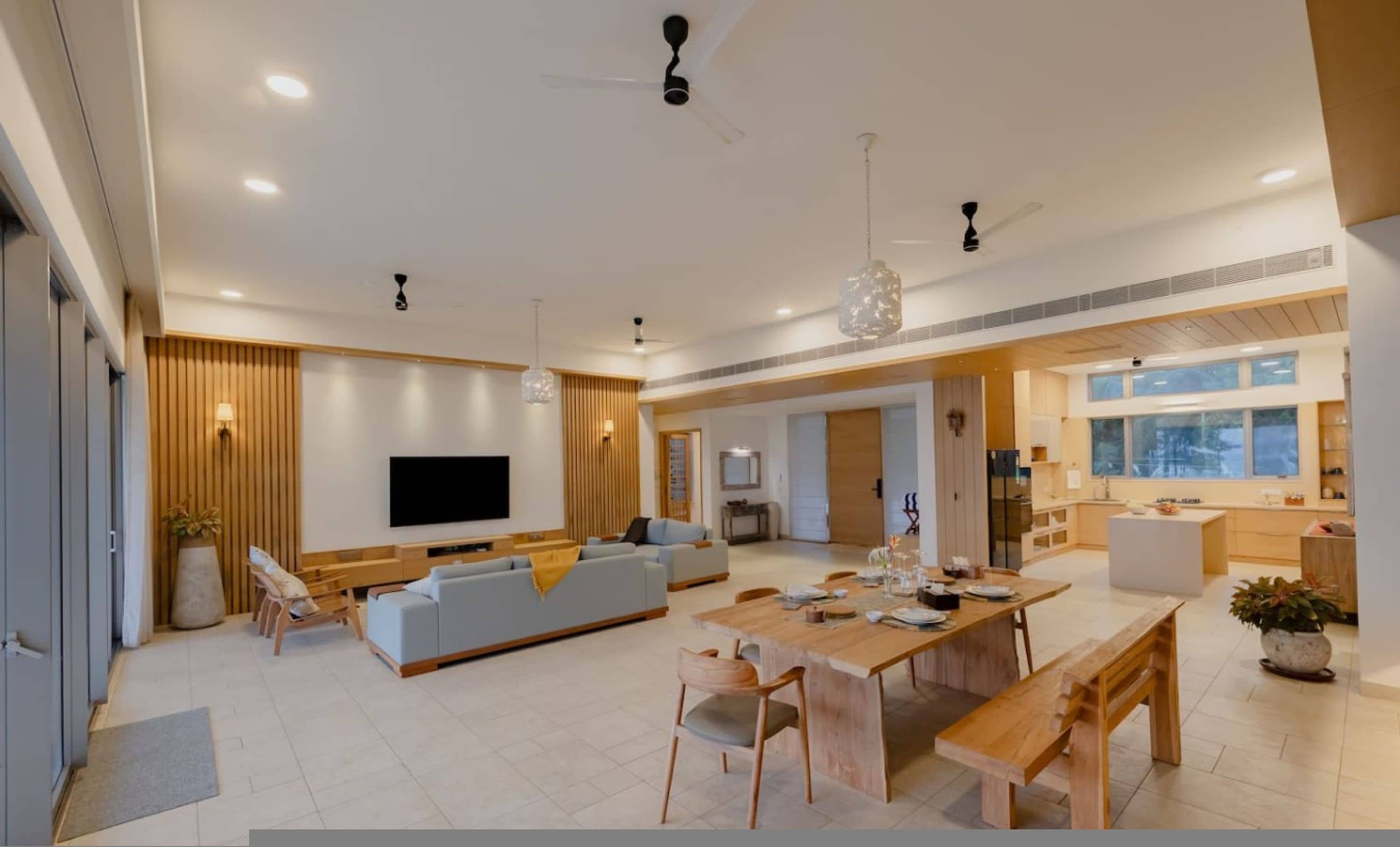 A spacious living area with a sofa, TV, and dining table.
