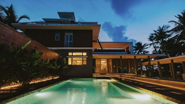 A modern two-story building with a swimming pool in the foreground. - Villa Shankari - Beachside 3BR w Private Pool (Udupi)