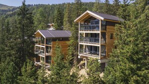 A two-story wooden cabin with balconies, surrounded by dense forest. - Superior Chalet # 27 With Sauna & Hot Tub (Stadl-Predlitz)