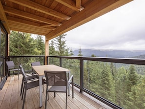 A wooden deck with a table and chairs, overlooking a forested landscape. - Superior Chalet # 27 With Sauna & Hot Tub (Stadl-Predlitz)