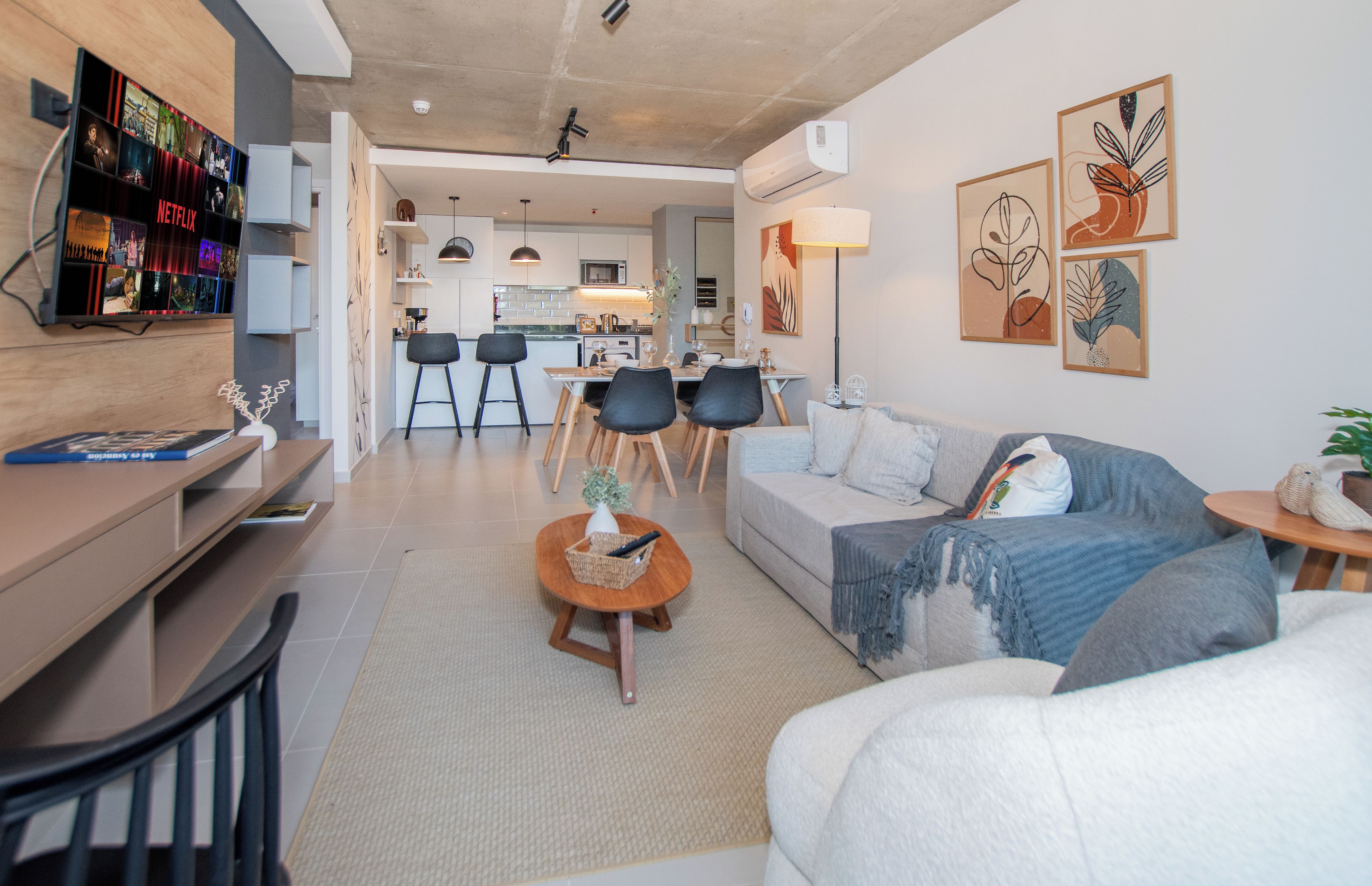 Una sala de estar moderna con sofá, mesa de centro y televisor montado en la pared.