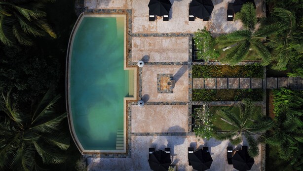 An aerial view of a swimming pool area with lounge chairs and umbrellas, surrounded by palm trees. - JH Villa Estate (Thalpe)